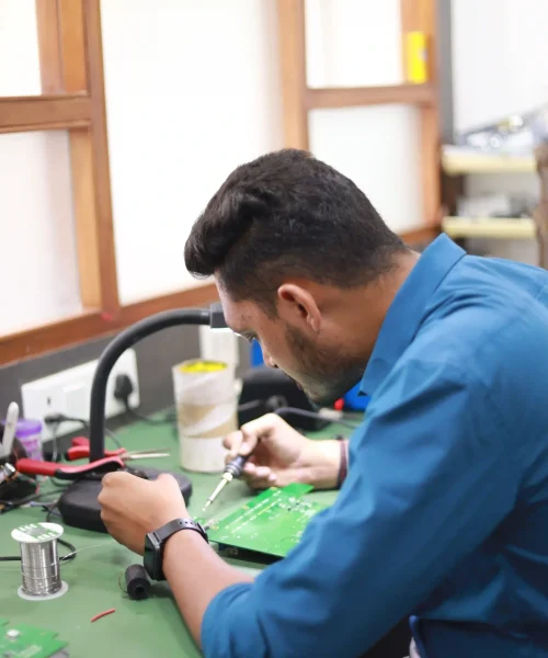 Jenex Technovation embedded hardware engineer working on a printed circuit board during embedded product development and testing.